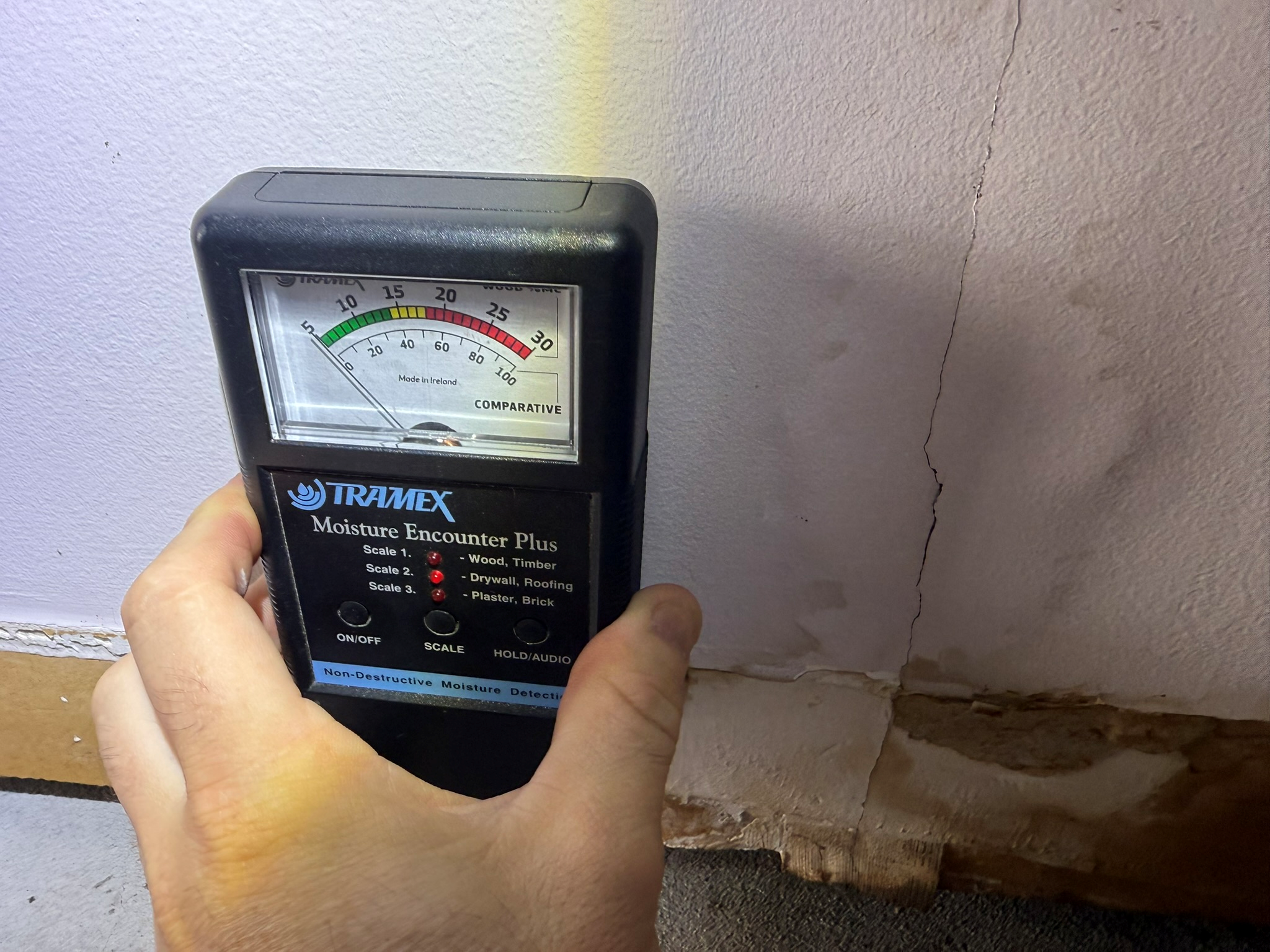 Building inspector using moisture meter in Belmont home